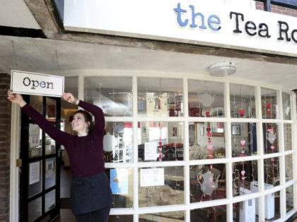 Harriet Henry, manager of The Tea Room in Knutsford, England, poses with the Open sign out