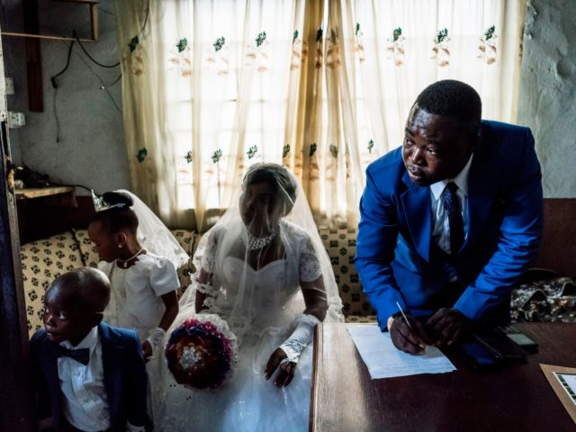 TOPSHOT - Chinyere (Godgiven) and her husband-to-be Jones (R) prepare wedding documents during a service at the Evangelic Calvary Life Mission Church on May 28, 2017 in the Osusu district of Aba. / AFP PHOTO / MARCO LONGARI (Photo credit should read MARCO LONGARI/AFP via Getty Images)