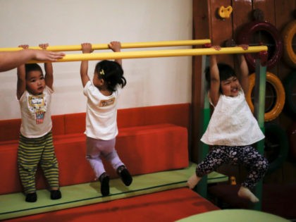 In this Wednesday, May 11, 2016 photo, children play on bars before attending a class at the I Love Gym center in Beijing. China’s decision to allow all married couples to have two children is driving a surge in demand for fertility treatment among older women, putting heavy pressure on …