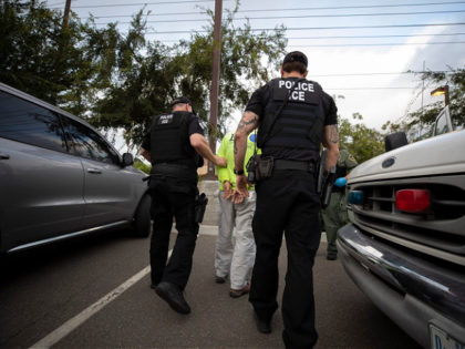 In this July 8, 2019, photo, a U.S. Immigration and Customs Enforcement (ICE) officers escort a man in handcuffs during an operation in Escondido, Calif. The carefully orchestrated arrest last week in this San Diego suburb illustrates how President Donald Trump's pledge to start deporting millions of people in the …