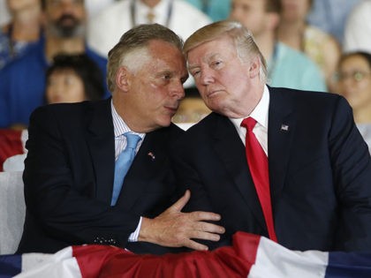 President Donald Trump, right, talks with Virginia Gov. Terry McAuliffe during commissioni