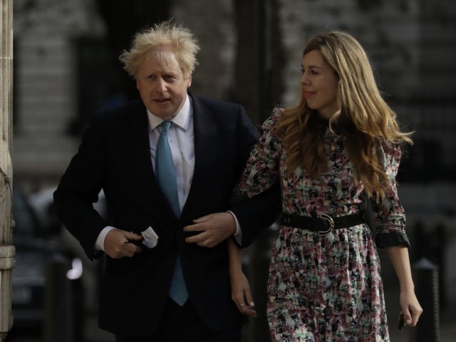 British Prime Minister Boris Johnson arrives at a polling station with his partner Carrie