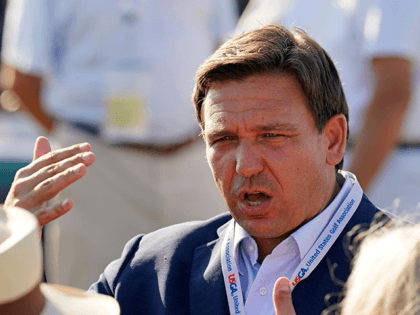 Florida Gov. Ron DeSantis talks with fellow patrons before the opening ceremony of the Walker Cup golf tournament, which starts tomorrow, at Seminole Golf Club in Juno Beach, Fla., Friday, May 7, 2021. (AP Photo/Gerald Herbert)