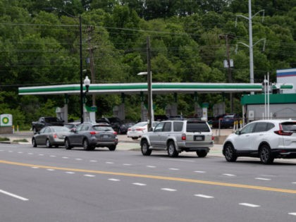 Cars line up to buy gasoline at a BP gas station in Arlington, Virginia on May 12, 2021. - Fears the shutdown of the Colonial Pipeline because of a cyberattack would cause a gasoline shortage led to some panic buying and prompted US regulators on May 11, 2021 to temporarily …