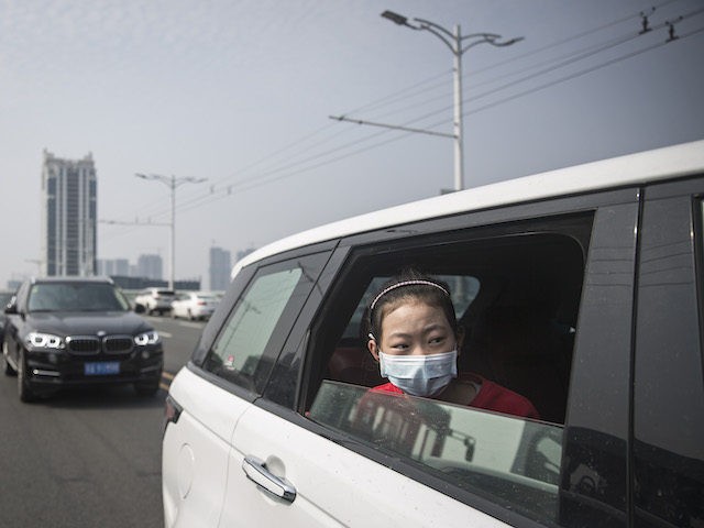 A girl sit in car while traffic stops during a silent tribute to martyrs who died in the fight against the novel coronavirus disease (COVID-19) outbreak and compatriots who died of the disease on April 4,2020 in Wuhan, Hubei Province, China.will lift the lockdown on April 8, local media reported. …