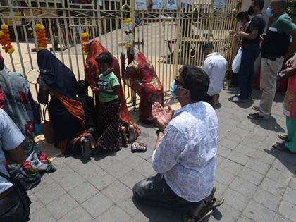 Christian devotees and faithful of other religions pray outside the closed gates of the St. Michael church in Mumbai on April 7, 2021 following restrictions imposed by the state government amidst rising Covid-19 coronavirus cases. (Photo by INDRANIL MUKHERJEE / AFP) (Photo by INDRANIL MUKHERJEE/AFP via Getty Images)