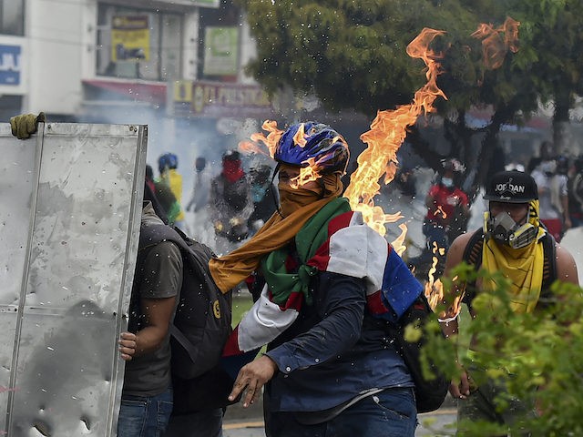 A demonstrator is hit by a Molotov cocktail thrown during clashes with riot police officers during a protest against a proposed government tax reform in Cali, Colombia, on May 3, 2021. - Protesters in Colombia on May 3 called for a new mass rally after 19 people died and more …