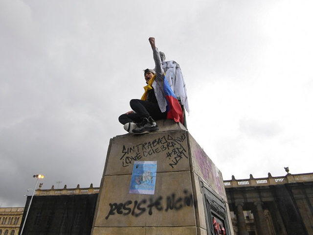 A student raises his fist from the top of a statue of liberator Simon Bolivar during the s