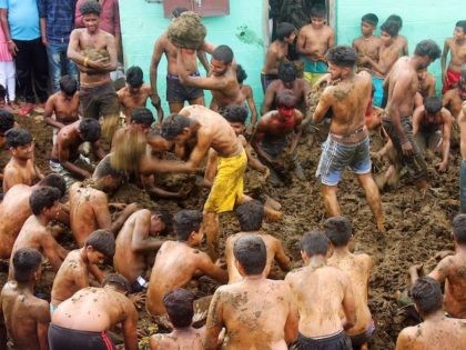 In this picture taken on November 17, 2020 people take part in "Gorehabba" festival at Gumatapura village on the border of India's Karnataka and Tamil Nadu states. - Laughing and cheering as they scoop up handfuls of cow dung to roll into balls, men and boys from a small village …