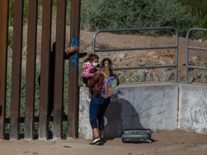 YUMA, AZ - May 13, 2021: A familiy of asylum seekers from Cuba jump the wall to turn themselves to the US Border Patrol Agents on May 12, 2021 in Yuma, Arizona. Migrants Continue To Cross Southern Border As Biden Administration Grapples With Surge. (Photo by Apu Gomes/Getty Images)
