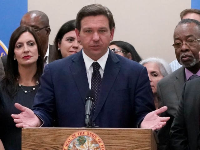 Florida Gov. Ron DeSantis, center, speaks before signing a bill that increases eligibility to attend private schools at public expense, during a ceremony at St. John the Apostle School, Tuesday, May 11, 2021, in Hialeah, Fla. The bill is projected to allow more than 60,000 previously ineligible students to seek vouchers. The cost to the state will be an estimated $200 million. (AP Photo/Wilfredo Lee)
