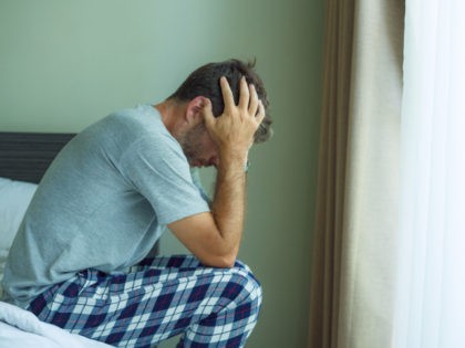 dramatic portrait of attractive scared and depressed 40s man on bed in pajamas feeling worried suffering anxiety and depression problem during virus quarantine home lockdown - stock photo dramatic portrait of attractive scared and depressed 40s man on bed in pajamas feeling worried suffering anxiety and depression problem during virus …