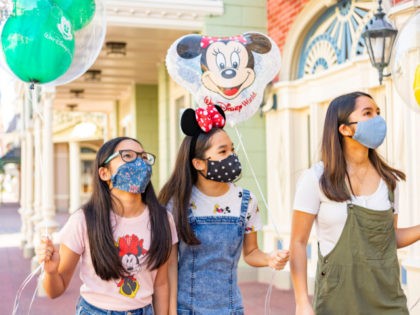 In this handout photo provided by Walt Disney World Resort, guests wear masks at Walt Disney World Resort on June 12, 2020 in Lake Buena Vista, Florida. All guests two years of age and older will be required to wear an appropriate face covering at all times, except when eating …