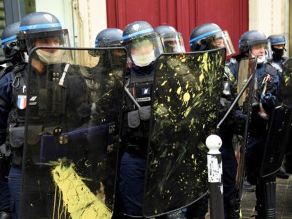 Police wearing riot gear hold shields stained with paint during the annual May Day (Labour Day) rally in Paris on May 1, 2021. (Photo by Bertrand GUAY / AFP) (Photo by BERTRAND GUAY/AFP via Getty Images)