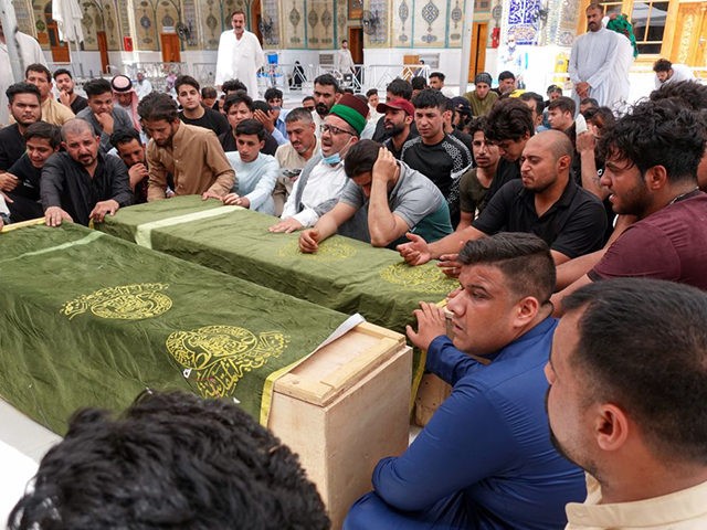 Iraqis mourn relatives killed during a fire in a hospital in the capital, during a funeral