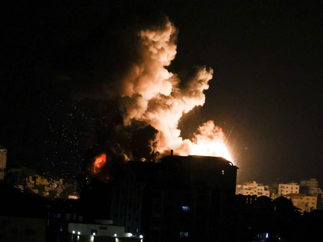 TOPSHOT - Fire billows from Israeli air strikes in the Gaza Strip, controlled by the Pales