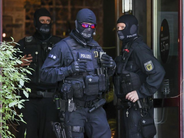 Federal police officers stand in front of a Vietnamese restaurant as part of a raid against a gang of smugglers in Leipzig, Germany, Monday, May 31, 2021. Authorities say suspects have been arrested in Germany and Slovakia in raids on a group accused of smuggling Vietnamese people into Germany and …