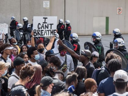 A woman holds a "I Can't Breathe" sign as Montreal Police and protesters face off during a march against police brutality and racism in Montreal, Canada, on June 7 2020. - On May 25, 2020, Floyd, a 46-year-old black man suspected of passing a counterfeit $20 bill, died in Minneapolis …