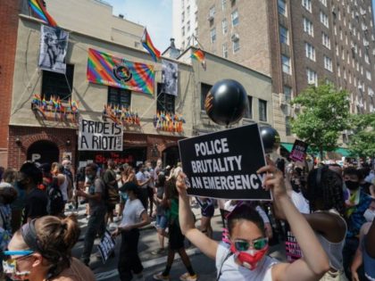 Protesters carrying signs walk past the Stonewall Inn during the Queer Liberation March hosted by The Reclaim Pride Coalition for Trans and Queer black lives and against police brutality in lower Manhattan on June 28, 2020 in New York. (Photo by Bryan R. Smith / AFP) (Photo by BRYAN R. …