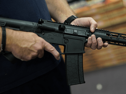 A customer handles an AR-15 at Jimmy's Sport Shop in Mineola, New York on September 25, 20