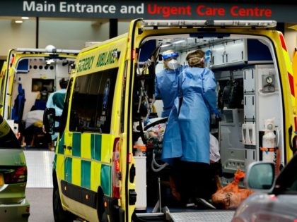 Paramedics prepare to remove a patient from an ambulance parked outside Guy's Hospital in London on December 29, 2020, as a new strain of the coronavirus appears to be behind the recent upsurge in cases, heaping further pressure on the state-run National Health Service during its busiest winter period. - …