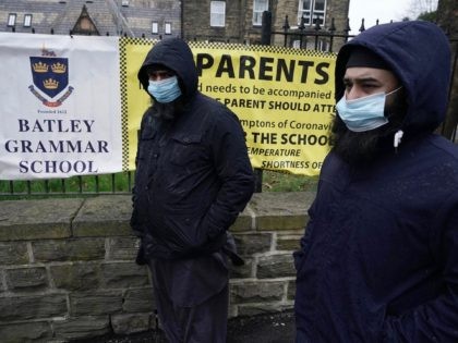BATLEY, ENGLAND - MARCH 26: People gather outside the gates of Batley Grammar School, afte