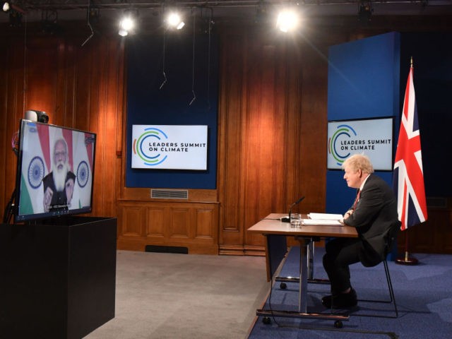 LONDON, ENGLAND - APRIL 22: Britain's Prime Minister Boris Johnson (R) listens as Indian Prime Minister Narendra Modi (screen) addresses the opening session of the virtual US Leaders Summit on Climate from the Downing Street Briefing Room on April 22, 2021 in London, England. (Photo by Justin Tallis - WPA …