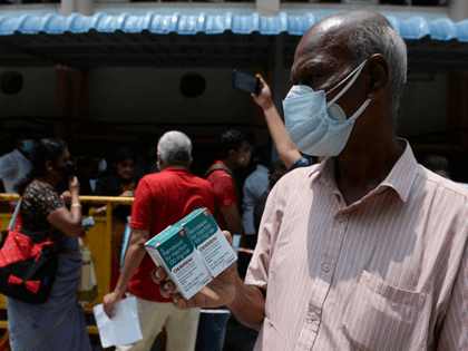 A man holds boxes of Remdesivir, an antiviral drug used to treat Covid-19 coroanavirus symptoms, purchased from government dispensary in Chennai on April 27, 2021. (Photo by Arun SANKAR / AFP) (Photo by ARUN SANKAR/AFP via Getty Images)