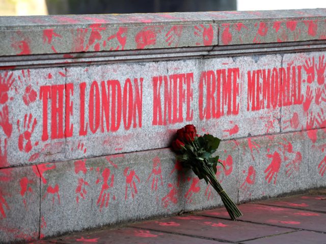 A bouquest is left at a mural to highlight knife crime in London on April 30, 2021. (Photo by Tolga Akmen / AFP) (Photo by TOLGA AKMEN/AFP via Getty Images)