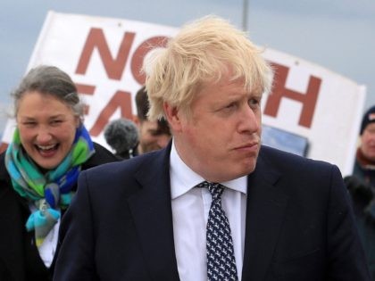 Britain's Prime Minister Boris Johnson (R) reacts as he campaigns on behalf of Conservative Party candidate Jill Mortimer (L) in Hartlepool, north-east England on May 3, 2021, ahead of the 2021 Hartlepool by-election to be held on May 6. (Photo by Lindsey Parnaby / POOL / AFP) (Photo by LINDSEY …
