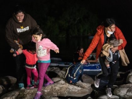 ROMA, TX - MAY 8: Asylum-seeking migrants' families walk away from the shore after crossin