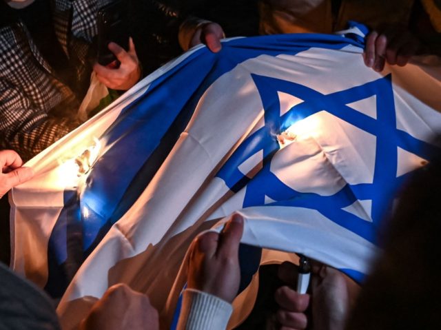 Protesters set an Israeli flag on fire during a demonstration against Israel in front of the Israeli Consulate in Istanbul, late on May 11, 2021. - A Palestinian was killed and another wounded by Israeli army gunfire in the north of the occupied West Bank on May 11, a Palestinian …