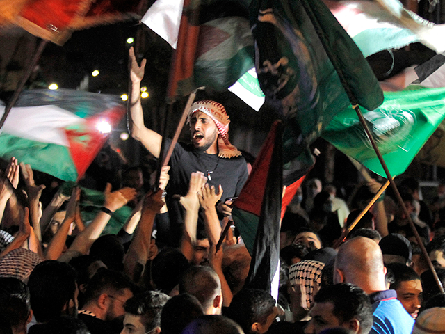 Men parade with Palestinian and Hamas flags during a demonstration called by the Palestini