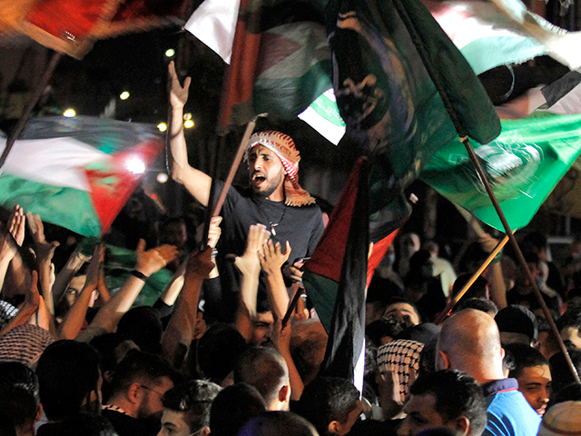 Men parade with Palestinian and Hamas flags during a demonstration called by the Palestinian Islamist group Hamas in the southern Lebanese city of Saida late on May 11, 2021. (Photo by Mahmoud ZAYYAT / AFP) (Photo by MAHMOUD ZAYYAT/AFP via Getty Images)