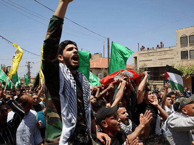 Palestinians wave the Hamas flag during the funeral of Rashid Abu Ara, 16, who was killed