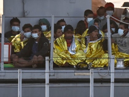 Migrants warmed by emergency blankets arrive on a boat of the Italian Guardia Di Finanza law enforcement agency on May 17, 2021 to disembark on the southern Italian Pelagie Island of Lampedusa. - More than 1,400 migrants arrived on the Italian island of Lampedusa at the weekend, sparking calls from …