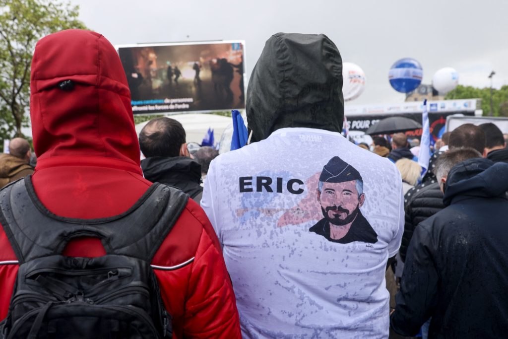 A protestor wears a shirt depicting a portrait of police officer Eric Masson, who was killed on May 5 during an anti-drug operation, as police officers gather for a rally in Paris on May 19, 2021, to demand harsher punishment for attacks against their own. (Photo: THOMAS COEX/AFP via Getty Images)