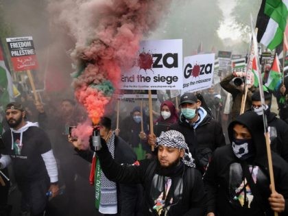 Pro-Palestine demonstrators hold placards as they gather to march in central London on May