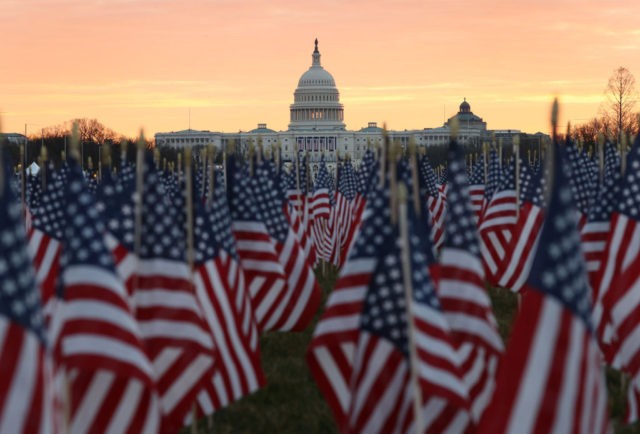 WASHINGTON, DC - JANUARY 18: The U.S Capitol Building is prepared for the inaugural ceremonies for President-elect Joe Biden as American flags are placed in the ground on the National Mall on January 18, 2021 in Washington, DC. The approximately 191,500 U.S. flags will cover part of the National Mall …