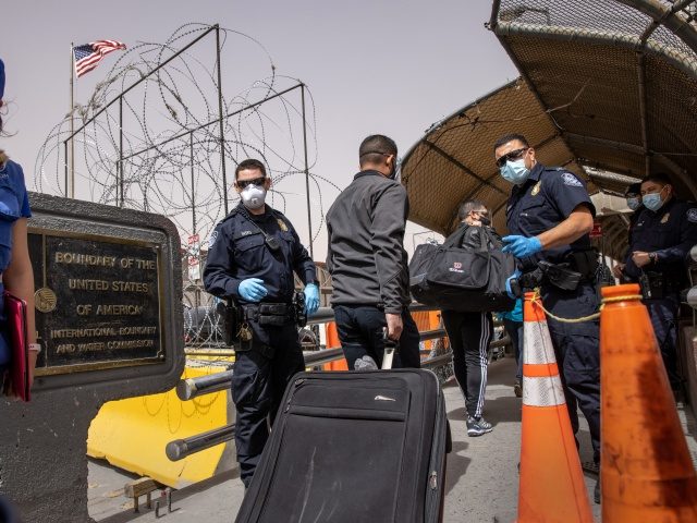 CIUDAD JUAREZ, MEXICO - MARCH 16: Asylum seekers walk past U.S. Customs and Border Protect