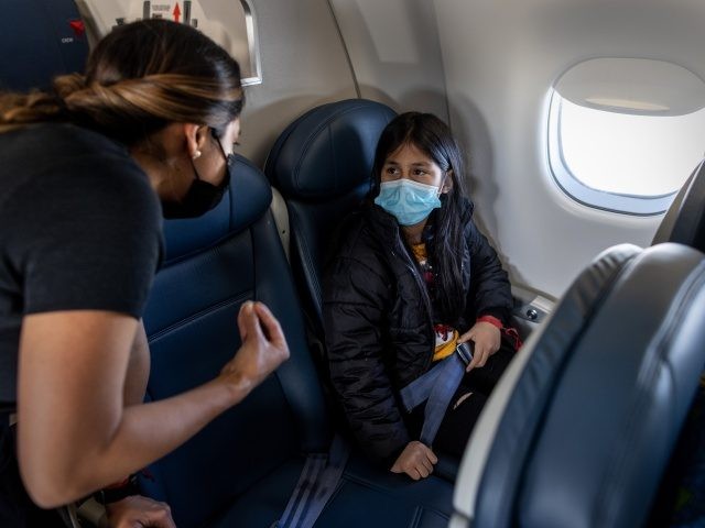IN FLIGHT - APRIL 23: Honduran immigrant Nani, 10, speaks with a flight attendant while flying to join her extended family in southern Indiana on April 23, 2021 near Louisville, Kentucky. The unaccompanied minor had been released that day from U.S. Health and Human Services custody after spending nearly eight …