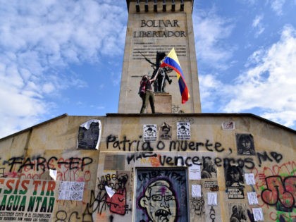 BOGOTA, COLOMBIA - MAY 04: A demonstrator waves a Colombian flag next to the monument of S