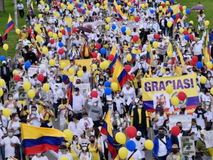 BOGOTA, COLOMBIA - MAY 30: Supporters of the government of President Ivan Duque wearing white t-shirts, holding white flowers, Colombian flags and signs in support of public forces take part in a movilization against violence on May 30, 2021 in Bogota, Colombia. According to José Uscátegui of Centro Democrático, public …