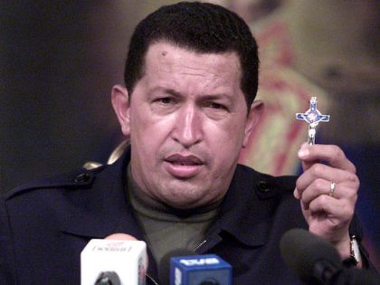 Venezuelan President Hugo Chavez holds a crucifix as he addresses the nation from the Miraflores presidential palace 14 April 2002 in Caracas. An emotional Chavez returned to the presidency of Venezuela 14 April 2002 after a two-day sojourn as a leader ousted in a coup d'etat. (Photo credit should read …