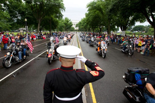 TOPSHOT - US Marine Tim Chambers salutes as participants in the Rolling Thunder annual motorcycle rally ride in Washington DC, on May 28, 2017. Motorcyclists are in Washington for the traditional annual Rolling Thunder ahead of Memorial Day, May 29. / AFP PHOTO / Jose Luis Magana (Photo credit should …