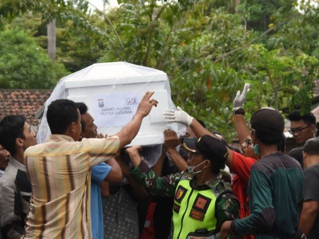 Relatives carry the coffin of Daniel Agung, who died in a blast at the Surabaya Centre Pentecostal Church, during his funeral in Surabaya on May 15, 2018. - Indonesia's elite anti-terror force Densus 88 conducted raids nationwide in the wake of a deadly wave of suicide bombings as calls grow …
