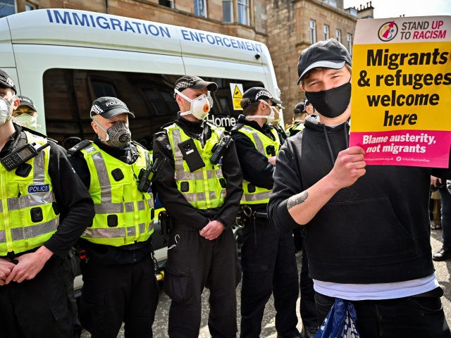 GLASGOW, SCOTLAND - MAY 13: Protestors block an immigration enforcement van, stopping it from leaving Kenmure Street in First Minister, Nicola Sturgeon's constituency on May 13, 2021 in Glsgow, Scotland. Police officers were called to Kenmure Street in Pollokshields, on the south side of the city, to support the UK …