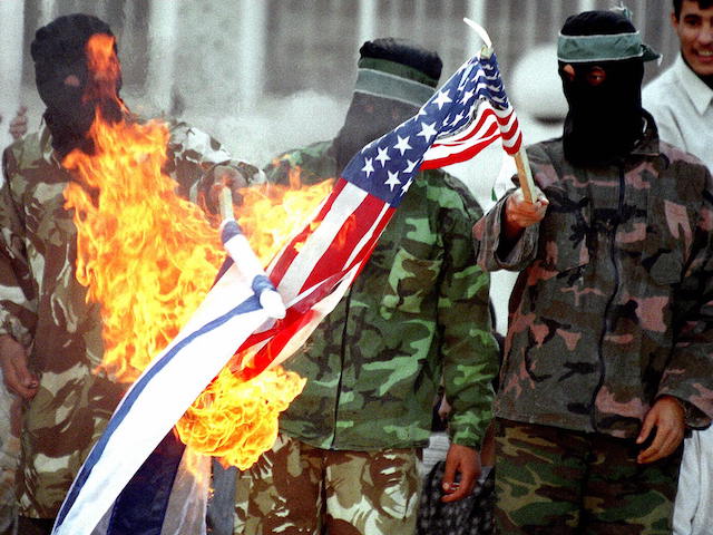 Palestinian demonstrators burn Israeli and American flags at a Hamas rally, 22 November, at Al-Najah University in Nablus. The demonstrators expressed their solidarity with a Palestinian woman, Itaf Elayan, who is on a hunger strike in an Israeli prison. (Photo by AWAD AWAD / AFP) (Photo by AWAD AWAD/AFP via Getty Images)