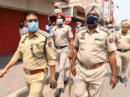 Police personnel patrol a market area during a lockdown imposed to curb the spread of the