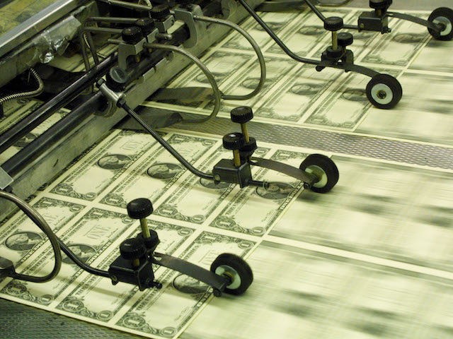 New Series 2001 one dollar bill notes pass through a printing press November 21, 2001 at the Bureau of Engraving and Printing in Washington, DC. The new dollar bills contain the signatures of U.S. Treasury Secretary Paul O''Neill and U.S. Treasurer Rosario Marin. (Photo by Alex Wong/Getty Images)